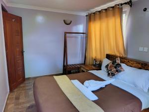 a bedroom with a large bed and a window at Pazuri Ark Gardens in Thika