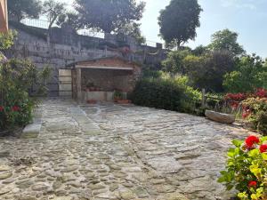 a stone courtyard with a building and flowers at Casa de Gándara in Baiona +16 photos