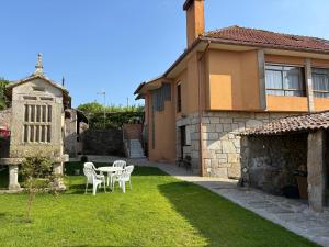 a yard with a table and chairs in a house at Casa de Gándara in Baiona