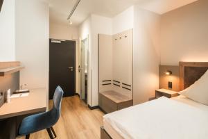 a bedroom with a bed and a desk and a chair at Hotel zur Post in Hemmingen