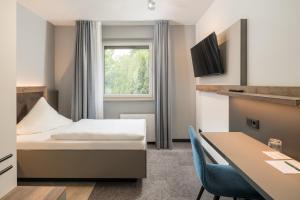 a hotel room with a bed and a table at Hotel zur Post in Hemmingen