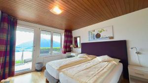 a bedroom with a large bed and a large window at Hotel Restaurant Panorama in Aeschlen