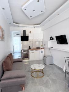 a living room with a couch and a table at Casa Luna Luxury Apartment in Nea Moudania