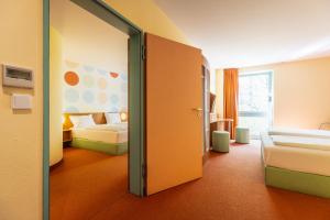 a hotel room with two beds and a sliding door at Hotel Holledau in Geisenhausen +165 photos