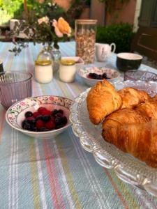 a table with plates of croissants and fruit on it at La MaiZon in Lazenay