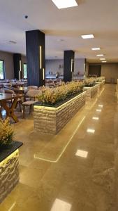 ein Esszimmer mit Tischen, Stühlen und Pflanzen in der Unterkunft Sever Suites Hotel in Antalya