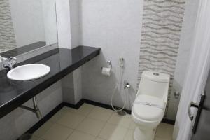 a bathroom with a white toilet and a sink at Hotel Angel in Greater Noida