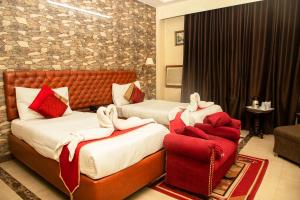 two beds in a hotel room with red and white towels at Hotel Angel in Greater Noida