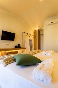 a bedroom with a bed with a tv on the wall at Zante Pantheon Hotel in Tsilivi