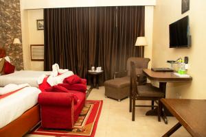 a hotel room with a bed and a chair and a desk at Hotel Angel in Greater Noida