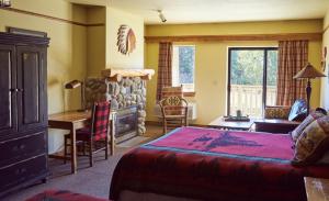 a bedroom with a bed and a desk and a fireplace at St. Mary Village in Saint Mary