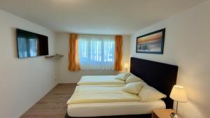 a bedroom with two beds and a window at Hotel Restaurant Panorama in Aeschlen