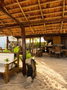 a restaurant with a wooden roof and tables and chairs at O'Sole Mio Assinie in Assinie