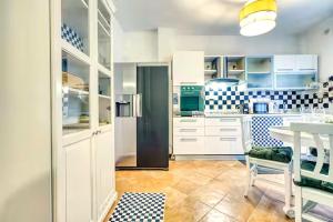 a kitchen with white cabinets and a table in it at Private Parking & Garden -Luxury B&B-700mt Tower in Pisa
