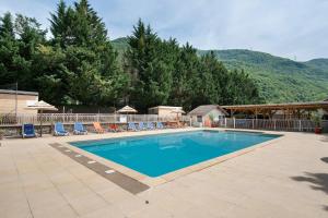 a large swimming pool with chairs and a fence at Camping L'imprévu in Vaulnaveys-le-Bas