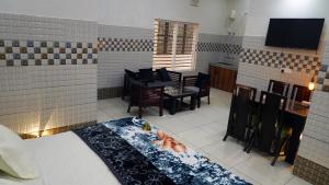 a living room with a table and chairs and a television at Kanta Sant Ram Aashram in Haridwār