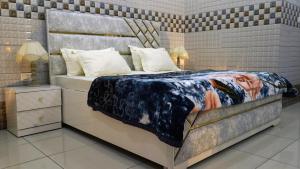 a bedroom with a large bed with a painting on it at Kanta Sant Ram Aashram in Haridwār