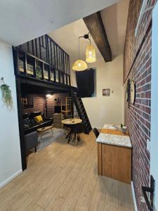 a living room with a staircase and a brick wall at Duplex à 15 min à pieds de la gare, centre historique Montluçon in Montluçon