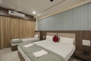 a bedroom with two beds at Royal Palace Hotel Surat Velanja in Sāyan