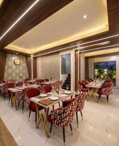 a restaurant with wooden tables and red chairs at Hotel Veloria Grand IGI Airport Delhi in New Delhi