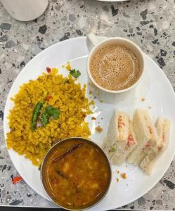 a plate of food with a cup of coffee and rice at Hotel Veloria Grand IGI Airport Delhi in New Delhi