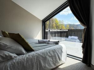 ein Schlafzimmer mit einem Bett und einem großen Fenster in der Unterkunft Apartamenty Malinka in Wisła + 31 Fotos