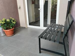 a black bench sitting on a porch with a potted plant at Adagio Sarafovo in Burgas +3 photos
