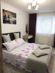 a bedroom with a large bed with pink flowers on it at Cazare Herculane in Băile Herculane