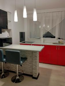 a kitchen with red cabinets and a white counter top at Cazare Herculane in Băile Herculane