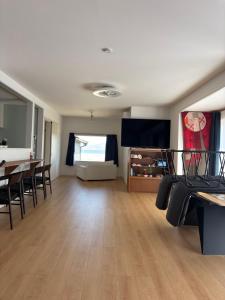 a living room with a table and chairs and a flat screen tv at Bluebase 波音 in Goto