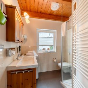 a bathroom with a sink and a toilet and a window at Nordsee-Apartments Hinrichsen in Husum +74 photos