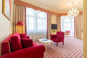 a living room with a red couch and chairs at Aviano Boutique Hotel in Vienna