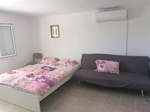 a bed and a couch in a room at Apatmani Čriček in Vlašići