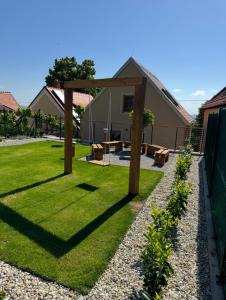 a garden with a wooden pergola and grass at Neobyčejný Sklep in Pavlov