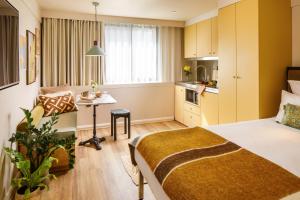 a small room with a bed and a kitchen at ARK Shoreditch in London