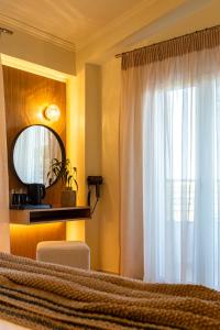 a bedroom with a bed with a mirror and a window at Zante Pantheon Hotel in Tsilivi