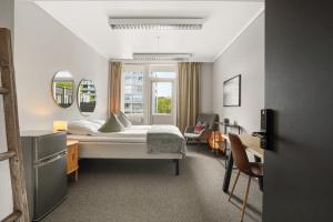 a bedroom with a bed and a table and chairs at A11 Apartments in Ålesund
