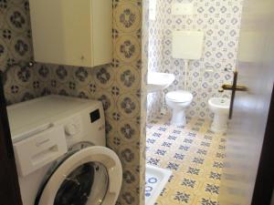 a bathroom with a washing machine and a toilet at Appartamento Island Brioni in Grado-Pineta