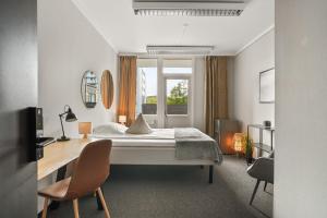 a bedroom with a bed and a desk and a window at A11 Apartments in Ålesund +47 photos