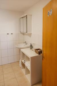 a small bathroom with a sink and a white counter at Haus Hermann in Schruns +29 photos