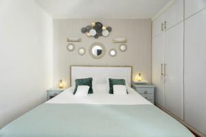 a bedroom with a large white bed with green pillows at Casa Amaoré in Alajeró +16 photos