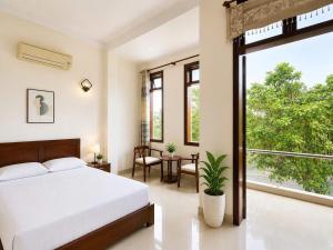 a bedroom with a bed and a large window at Hani Motel Da Nang in Danang