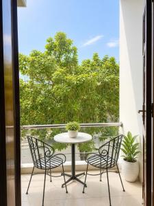 a table and chairs on a balcony with a window at Hani Motel Da Nang in Danang