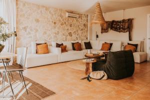 a living room with a white couch and a table at Casa Stellar - boutique villa with private pool and sea view - sustainably solar powered in Sant Josep de sa Talaia