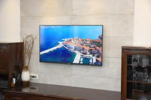 ein Flachbildfernseher, der an einer Wand hängt in der Unterkunft Apartments Romana in Postira