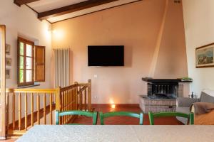 a living room with a fireplace and a flat screen tv at Podere Par di Rota in Calci