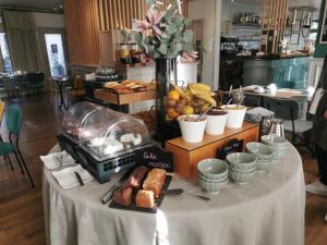 a table with some bread and other food on it at Hôtel Le Normandy - Maison Tassoni in Vernon
