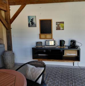 a room with a counter with a microwave on a wall at Chambre d'hôtes Le Nid'zen in Le Nizan
