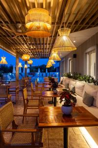 a living room with tables and chairs and chandeliers at Zante Pantheon Hotel in Tsilivi +37 photos