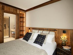 a bedroom with a white bed with wooden walls at Les Chalets de l'Observatoire in Megève